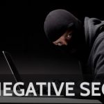 Man with ski mask on leaning over a laptop to show Negative SEO
